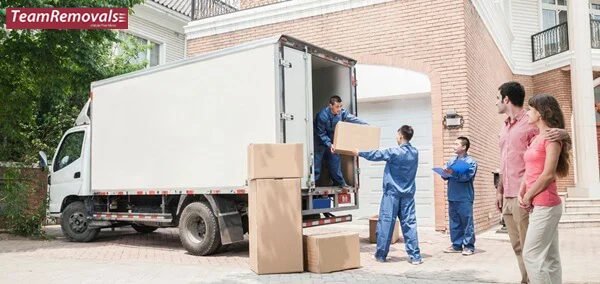 Removalists loading household items onto moving truck