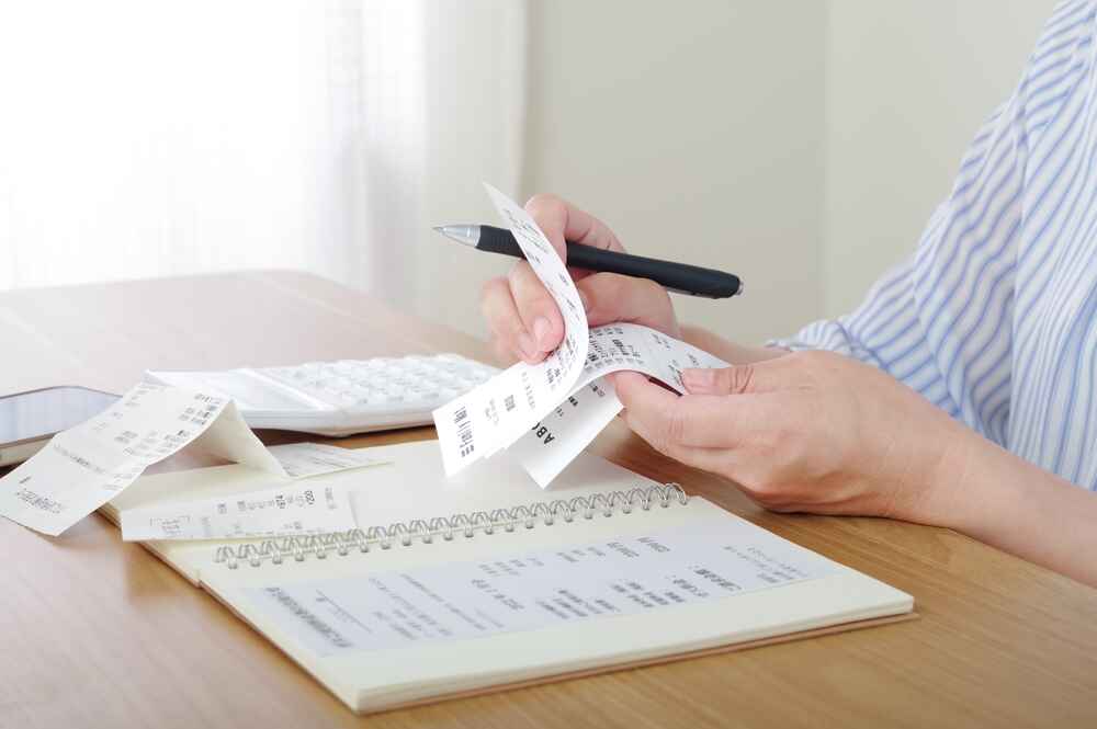 A Woman Calculating Her Monthly Expenses In Brisbane