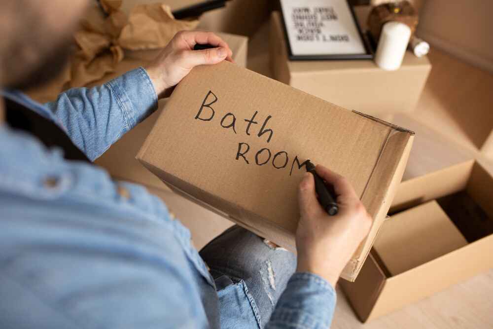 A man labelling moving boxes